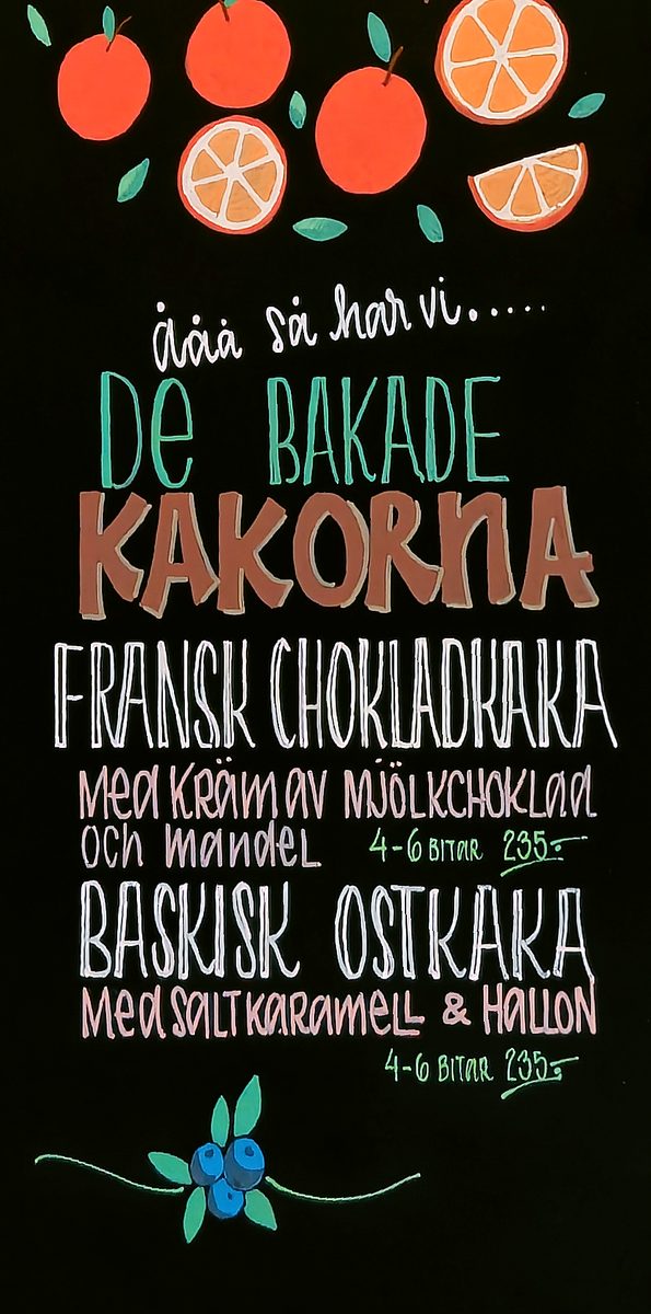 Tall bakery menu board with hand lettering and illustrated fruit